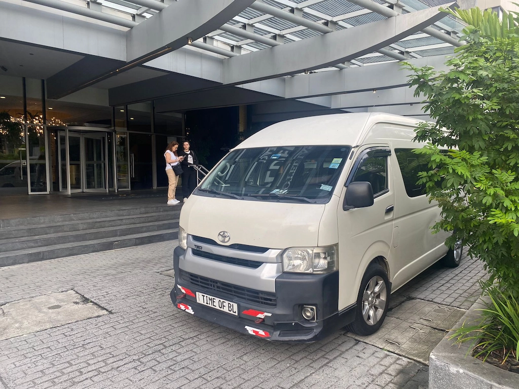 Vehículo tipo van ejecutiva esperando en la entrada de hotel para traslado privado en Ciudad de Panamá